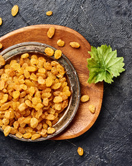 Wall Mural - Yellow raisins on black concrete background. Top view of dried grapes.