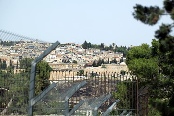 view of the old city of Jerusalem in Israel with an olive mountain. view through the fence with barbed wire