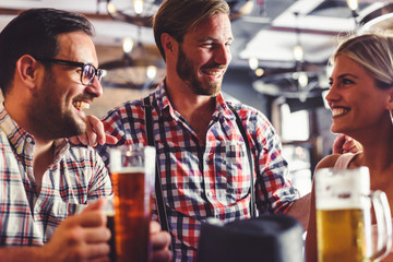 Wall Mural - Happy friends having fun at bar - Young trendy people drinking beer and laughing together