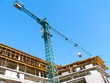 © fotolian121212 - The crane lifts the load with concrete blocks.Construction site with hoisting crane and building.Scaffolding.