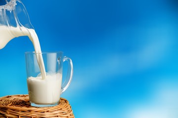 Canvas Print - Glass of milk and jug on wooden background