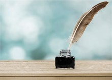Feather Quill Pen And Glass Inkwell Isolated On A White