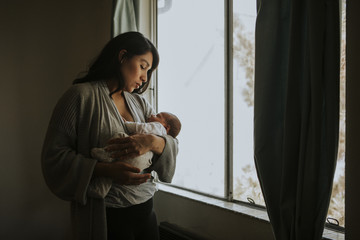 Wall Mural - mother holding her baby indoors
