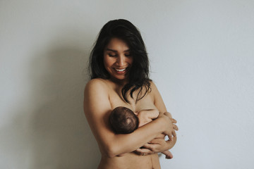 Wall Mural - naked mother holding her newborn baby