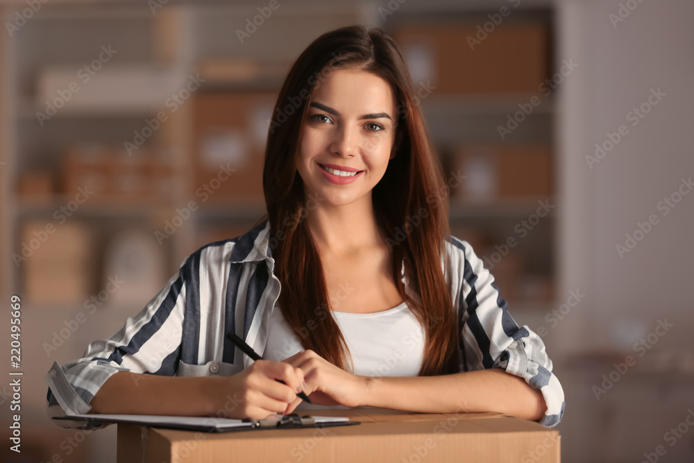 Young woman preparing parcel for shipment to client in home office