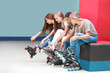 © Africa Studio - Group of teenagers putting on roller skates indoors