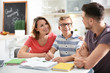© Africa Studio - Teenager with parents doing homework at home