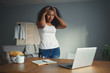 © Anatoliy Karlyuk - Horizontal shot of desperate young Afro American woman freelancer holding hands on her head, feeling stressed and panic because of deadline or computer problem, standing at desk with open laptop