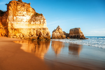 Wall Mural - beautiful ocean landscape, the coast of Portugal, the Algarve, rocks on the sandy beach, a popular destination for travel in Europe