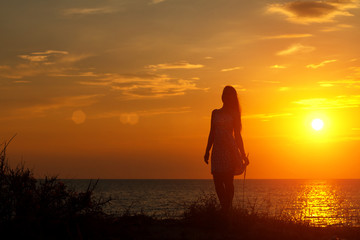 silhouette of a young woman on the beach at sunset