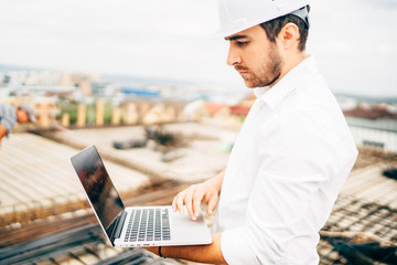 Wall Mural - Close up details of young architect using laptop on building construction site