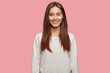 © wayhome.studio  - Isolated shot of pleasant looking cheerful brunette youngster has appealing look, healthy skin, dressed in casual white sweatshirt, poses against pink studio wall. Happiness and lifestyle concept