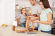 © Africa Studio - Happy family having breakfast with toasts in kitchen