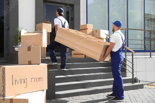 Fotografía Male movers carrying shelving unit into new house