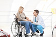 © Africa Studio - Male doctor taking care of mature woman in wheelchair indoors