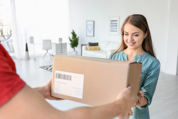 Wall Mural - Young woman receiving parcel from courier