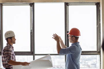 Wall Mural - two active , sucessful builders are discussing a blueprint. panorama window on the background of the photo