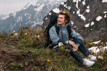 Wall Mural - good looking tourist in jacket , jeans, trainers, backpack on the fantastic scenery. side view photo