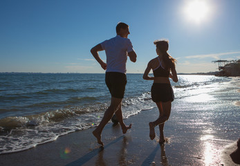 father and daughter running along the seashore