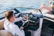 Wealthy succsessful businessman rent a speed luxury motor boat to take a drive with his new passion- young pretty girl with good slim body dressed in bikini.