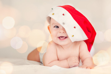 Beautiful little baby celebrates Christmas New Year's holidays Baby red hat boken background