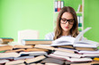 © Elnur - Young female student preparing for exams with many books