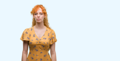 Poster - Young redhead woman with serious expression on face. Simple and natural looking at the camera.