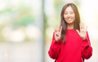 © Krakenimages.com - Young asian woman wearing winter sweater over isolated background showing and pointing up with fingers number nine while smiling confident and happy.