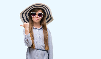 Sticker - Young blonde toddler wearing hat and sunglasses pointing with hand and finger up with happy face smiling