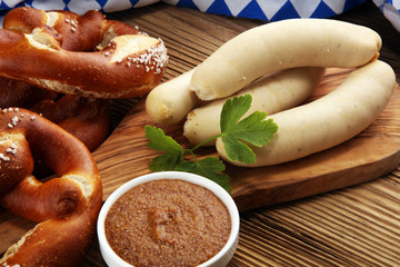 Wall Mural - Bavarian veal sausage breakfast with sausages, soft pretzel and mild mustard on wooden board from Germany