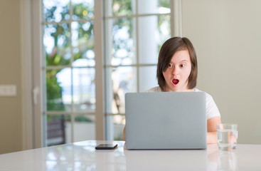 Sticker - Down syndrome woman at home using computer laptop scared in shock with a surprise face, afraid and excited with fear expression