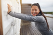 © Flamingo Images - Smiling young Asian woman stretching outdoors before a run