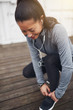 © Flamingo Images - Fit young Asian woman tying up her shoelaces before jogging