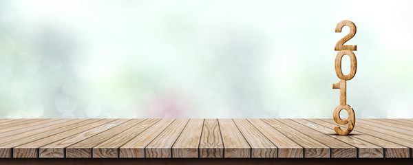 Poster - New year 2019 wood number (3d rendering) on wooden table at blur abstract green bokeh background,Mock up banner space for display or montage of product,holiday celebration greeting card.