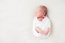 Cute Newborn Baby Lies Swaddled In A White Blanket. Copy Space And Top View