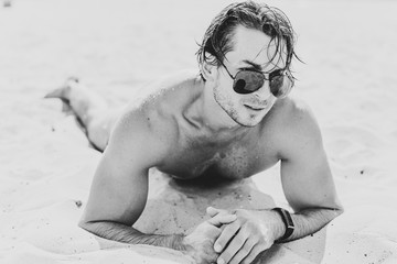 Muscular young athletic sexy man on the beach with a fit torso. Strong and handsome. Portrait of young european man on the sea beach. 