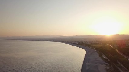 Wall Mural - Tramonto oltre la silhouette delle montagne controluce in riva al mare. Vista aerea.
