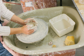 working with clay on potter's wheel, closeup of hands, crafts and arts