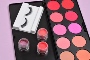 Professional makeup products with cosmetic beauty products, blushes, eye liner, eye lashes, brushes and tools.