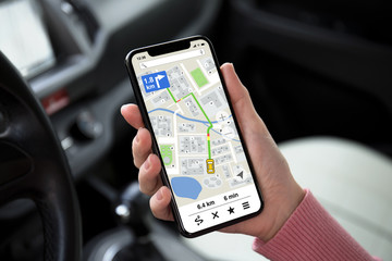 women hand holding phone with app navigation map on screen