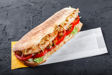 Canvas Print - Sandwich from fresh pita bread with fillet grilled chicken, lettuce, slices of fresh tomatoes, pickles and cheese