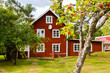 A typical red and white Scandinavian house for a family on the countryside in Sweden with a lot of garden around it