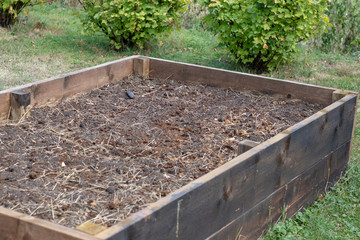 Canvas Print - Brown soil in an raised bed for vegetable patch in the garden