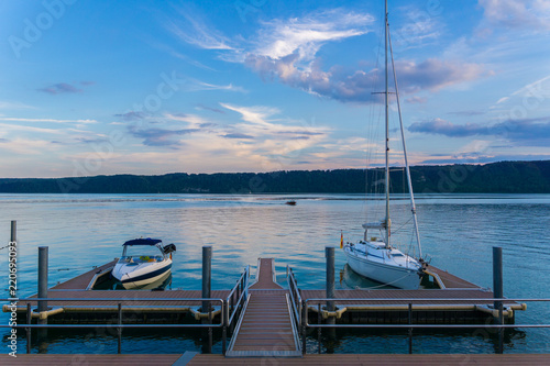 Fotografía Two boats at landing stage on silent water in twilight atmosphere