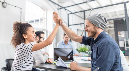 Fototapete - Happy business people team giving high five in office.