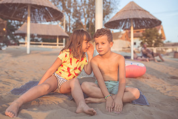 Little girl is whispering a secret into her friends ear