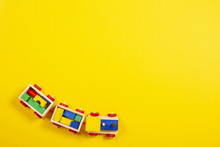 Wooden Toy Train With Colorful Blocks On Yellow Background