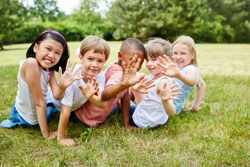 Children at meadow happily waving