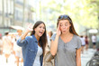 Teen greeting and friend ignoring her in the street