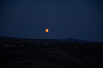 Canvas Print - Blood moon rising over Tuscan countryside, Italy